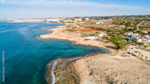 Aerial bird's eye view of Ammos tou Kambouri beach, Ayia Napa, Cavo Greco, Famagusta, Cyprus. Tourist attraction bay, rocky beach with golden sand, sunbeds, sea restaurant in Agia Napa from above.