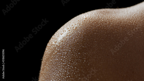 Macro shot of wet skin of young African American female model on black background | Skin texture shot for skin hydration concept