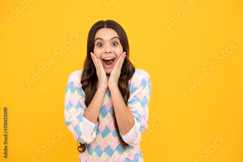 Shocked teenager child with amazed look on yellow background, amazement. Excited face. Amazed expression, cheerful and glad.
