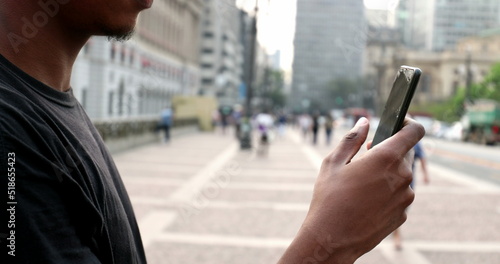 Wallpaper Mural Black man using cellphone in city downtwon. African guy holding smartphone Torontodigital.ca