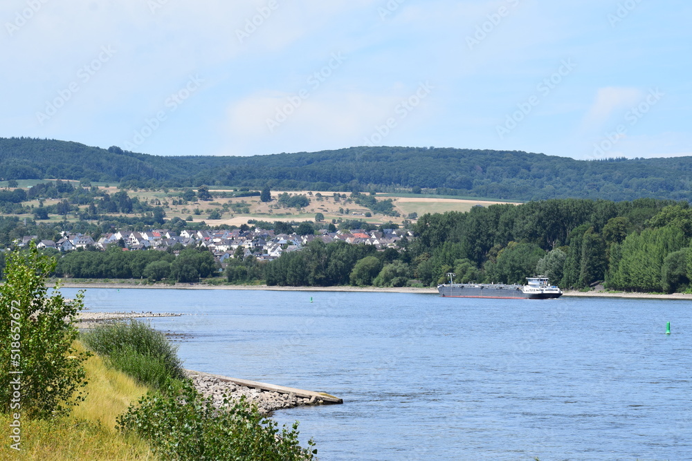 Fototapeta premium niedriger Wasserstand im rHein mit einem leichten Frachtschiff