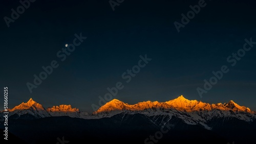 Fotografiet Beautiful landscape of mountains covered in snow on the sunrise
