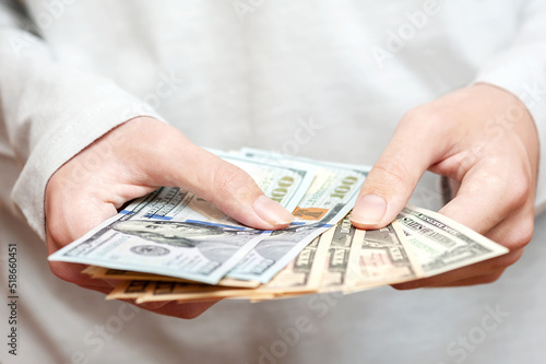 Hands holding a stack of money, cash, currency, economy