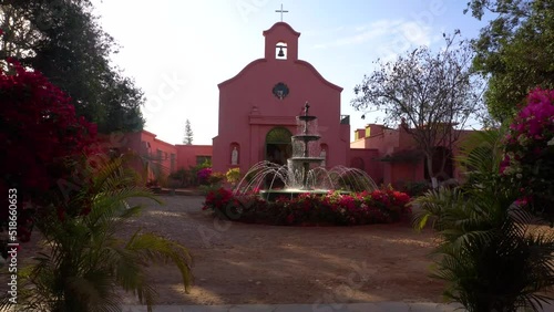 Old church with a fountain adorned with flowers on a sunny day in Hacienda Bodega Tacama photo