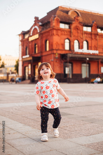 little girl walking and playing on the street in summer