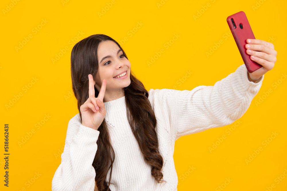 Kids selfie. Mobile online shopping. Cute teen child girl paying with phone, texting and chatting on smartphone. Happy face, positive and smiling emotions of teenager girl. Kids selfie. Mobile online shopping. Cute teen child girl paying with phone, texting and chatting on smartphone. Happy face, positive and smiling emotions of teenager girl.