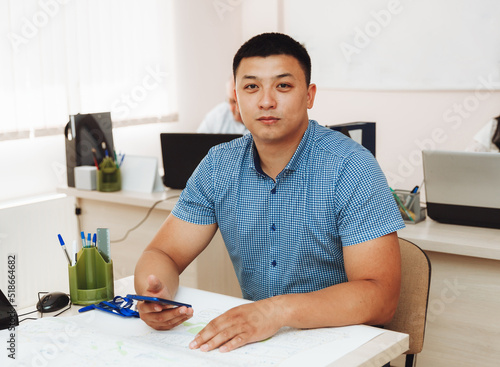 A young Asian businessman with his arms crossed on his chest in the office. portrait of a business man