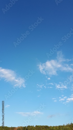 Photography Vertical shot of a blue sky with small clouds fading away