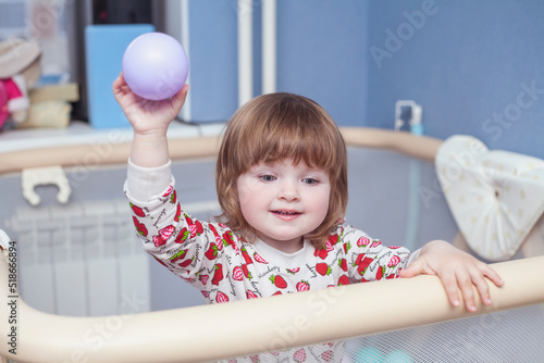 little baby girl in playpen having fun photo