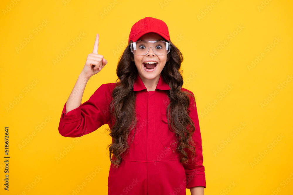 Excited teenager girl. Worker teenager child wearing overalls red, cap and protect glasses. Studio shot portrait isolated on yellow background. Excited teenager girl. Worker teenager child wearing overalls red, cap and protect glasses. Studio shot portrait isolated on yellow background.