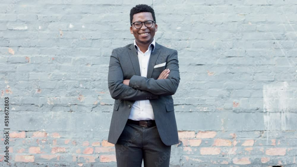 Proud and confident young African American businessman in suit and glasses smiling and crossing his arms. Financial advisor is happy that his counseling paid off. Entrepreneur satisfied with success Proud and confident young African American businessman in suit and glasses smiling and crossing his arms. Financial advisor is happy that his counseling paid off. Entrepreneur satisfied with success