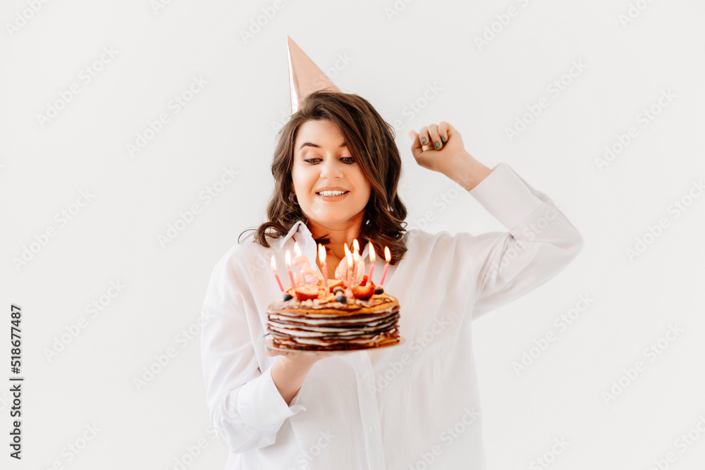 a funny woman with a birthday cake with candles. a funny woman with a birthday cake with candles.