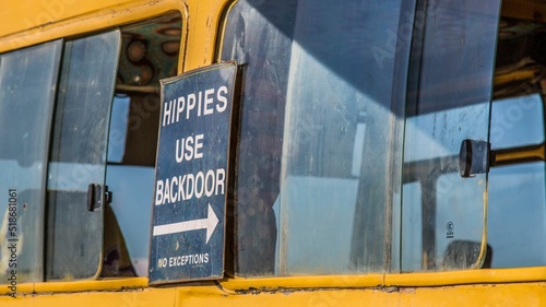 Photo Closeup of a sign about hippies entrance on an old yellow bus window