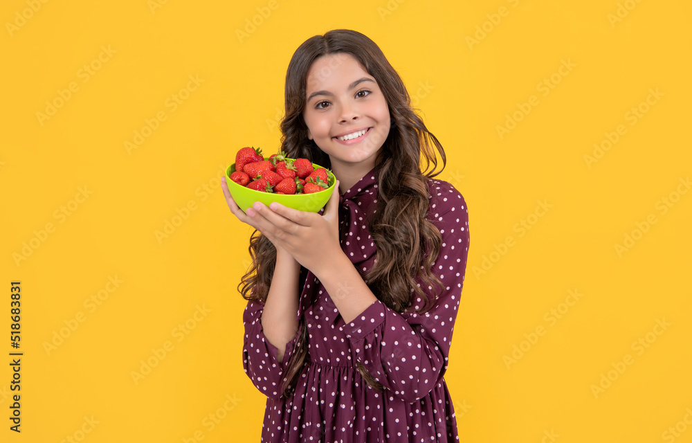 smiling teen girl hold strawberry bowl on yellow background smiling teen girl hold strawberry bowl on yellow background