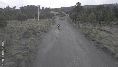 Amecameca State of Mexico Droneshot aerial shot of a guy running a motorcicle in a dusty dirt road in Iztaccihuatl Popocatepetl Izta-Popo national park photo