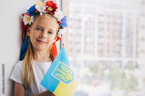 Girl with a flag of Ukraine. Child. Ukrainian child. War. Blue. Yellow. Pray for Ukraine. Ukrainian wreath on the head