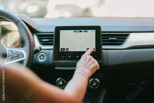 unrecognizable caucasian woman operating her car's navigator