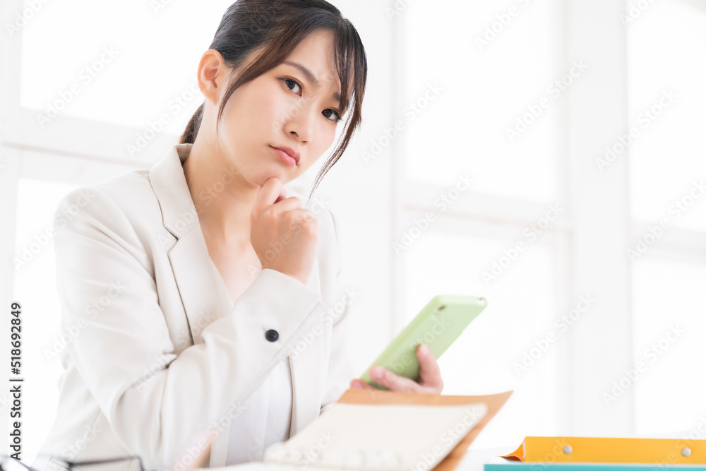 スマートフォンを見る女性 ビジネス 考える スマートフォンを見る女性 ビジネス 考える