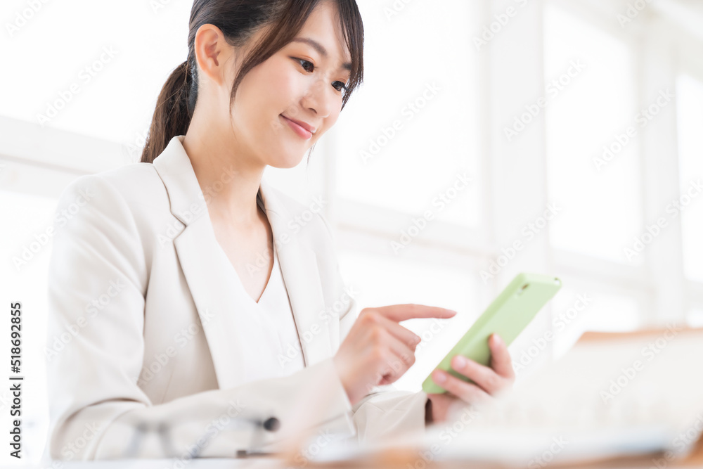 スマートフォンを見る女性 ビジネス スマートフォンを見る女性 ビジネス