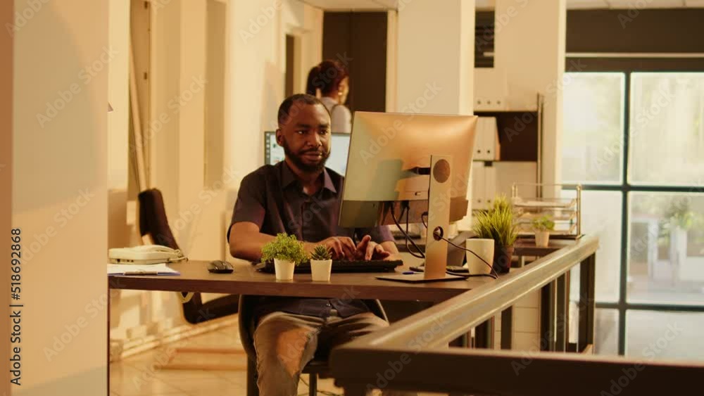 Male employee browsing internet on computer in business office, using research data information to plan startup report. Working on web presentation during sunset, executive job. Male employee browsing internet on computer in business office, using research data information to plan startup report. Working on web presentation during sunset, executive job.