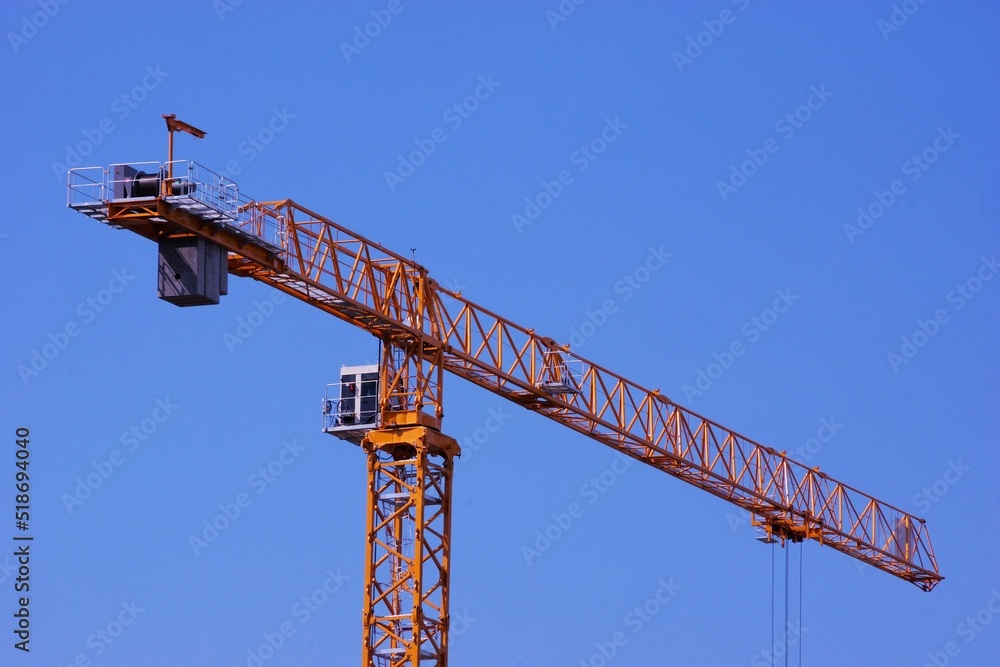 Tower construction crane, lifting mechanism with a rotary boom, against the sky. Tower construction crane, lifting mechanism with a rotary boom, against the sky.