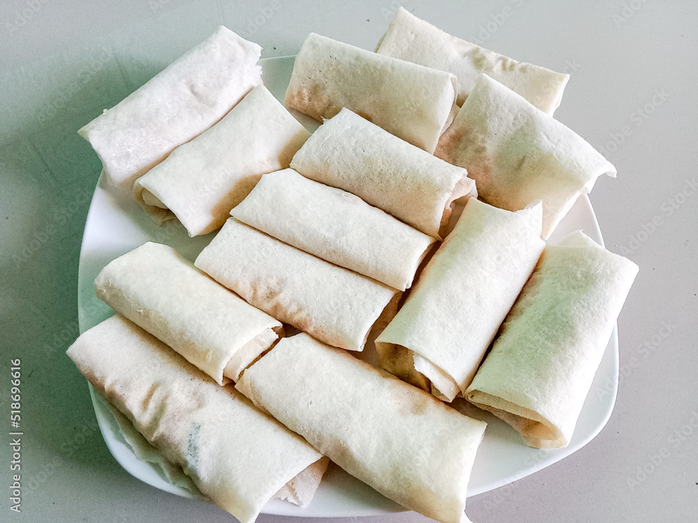 Raw spring rolls or lumpia, on the plate. Lumpia or lunpia, a traditional food from Semarang, Indonesia. Raw spring rolls or lumpia, on the plate. Lumpia or lunpia, a traditional food from Semarang, Indonesia.