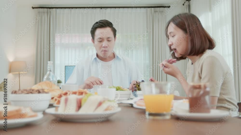 Happy family enjoy eating breakfast, Asian man and woman, husband and wife eating food Happy family enjoy eating breakfast, Asian man and woman, husband and wife eating food