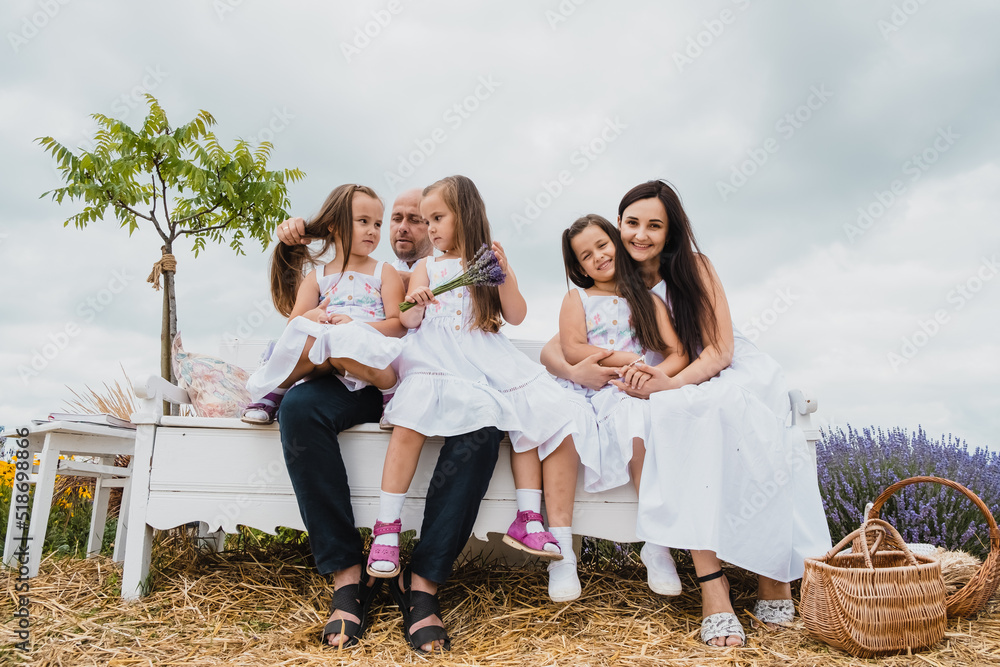 Fototapeta premium Happy kids dad and mom are kiss.The family spends leisure time in the fresh air. Native sisters are having fun. 