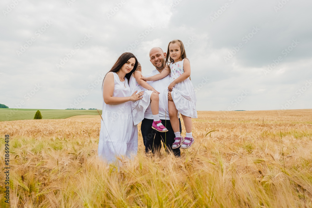 A mother and her daughter are having fun in a wheat field. Smiling dad in a White shirt enjoying time with little daughter in summer day. A mother and her daughter are having fun in a wheat field. Smiling dad in a White shirt enjoying time with little daughter in summer day.
