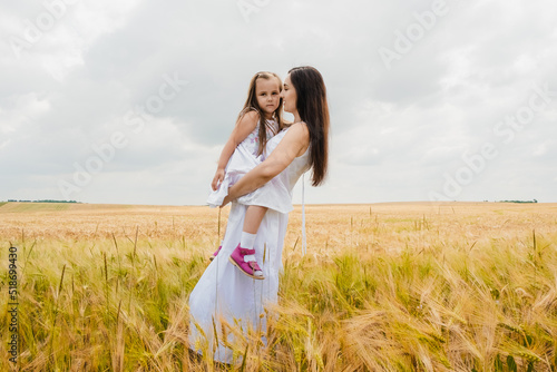 Cheerful children picnicking in the park.Mom and daughter in wheat photoset, holidays, recovery.
