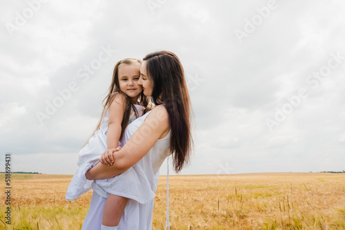 Mother and daughter hug in a wheat field.Cute beautiful children.Family vacation