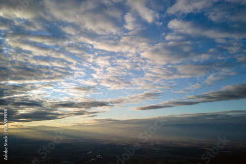 Aerial view at high altitude of dense puffy cumulus clouds forming before rainstorm in evening © bilanol