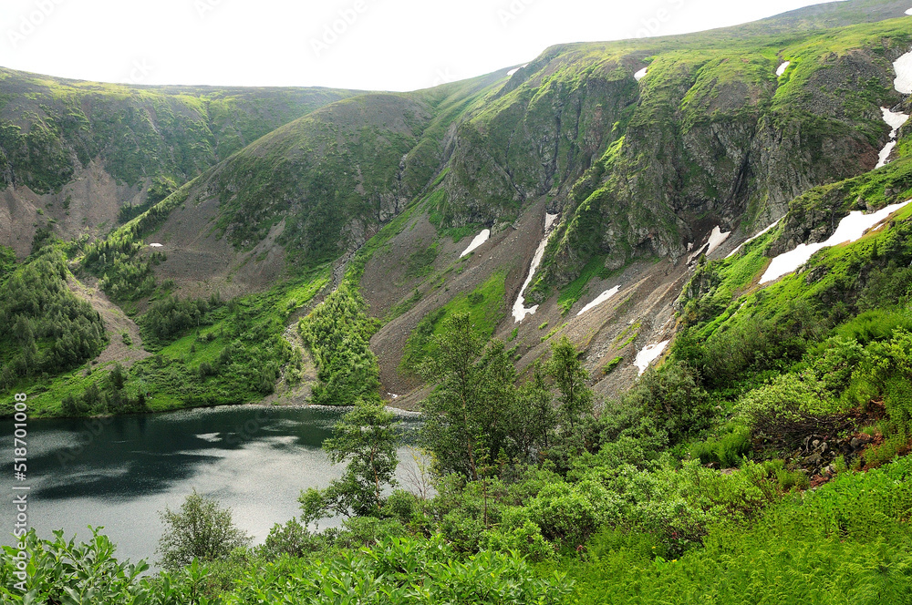 A beautiful lake surrounded by mountains with the remains of snow on the slopes. A beautiful lake surrounded by mountains with the remains of snow on the slopes.