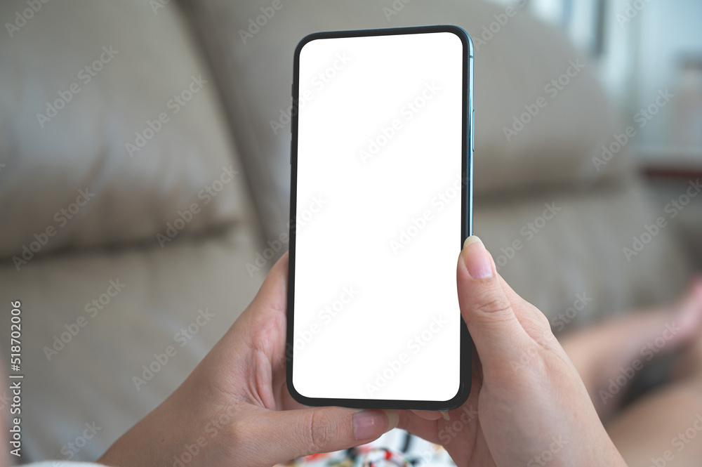 Close up relax women using a smartphone with an empty white screen lazy on the sofa at home. Close up relax women using a smartphone with an empty white screen lazy on the sofa at home.
