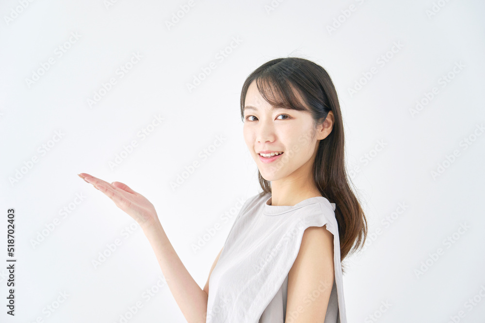 掌で左側を指す女性 白バック 掌で左側を指す女性 白バック
