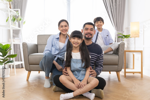 Portrait of asian family mother father and kids at home on sofa in living room.happy family concept.