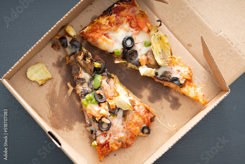 leftover vegi vegetable pizza in soiled cardboard box photo