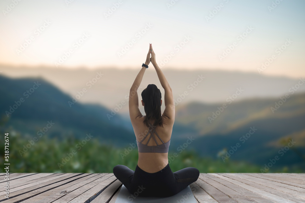 Foto de Woman practicing yoga and meditating outdoor exercise. Beautiful  girl practice yoga pose and body balance vital zen meditation for workout  nature mountain background in morning sunrise. do Stock