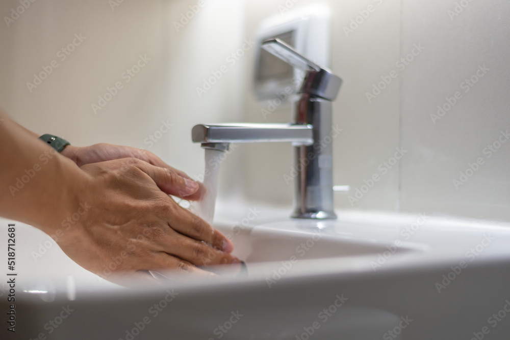 Close up image of hand washing hands with soap and clean water at the bathroom sink. Washing your hands frequently with soap and water helps to reduce viruses and bacteria. Close up image of hand washing hands with soap and clean water at the bathroom sink. Washing your hands frequently with soap and water helps to reduce viruses and bacteria.