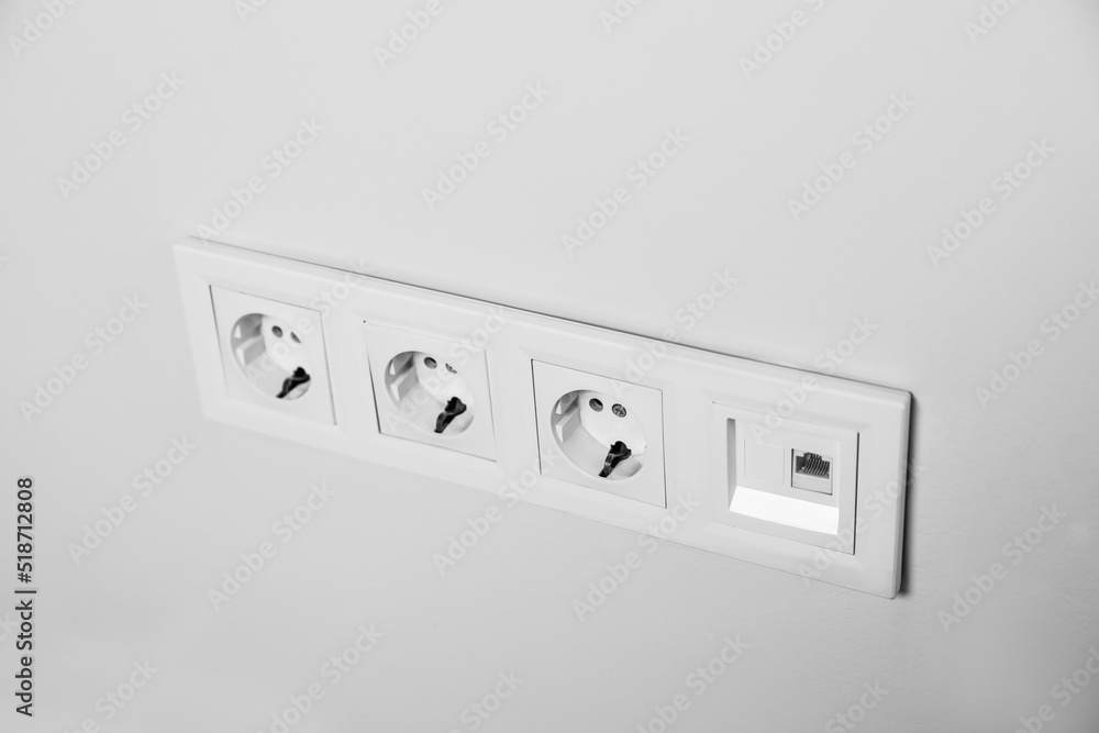 Power sockets on white wall, closeup. Electrical supply Power sockets on white wall, closeup. Electrical supply