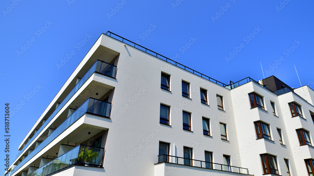 Obraz premium Exterior of new apartment buildings on a blue cloudy sky background. No people. Real estate business concept.