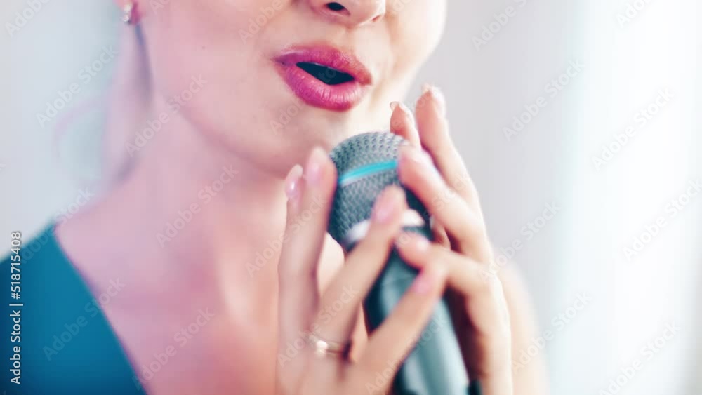 4k Beautiful woman singing. Close portrait with lips and microphone. Good articulation for music lesson and tutorial. Female vocalist emotional professional expression. White light studio. 4k Beautiful woman singing. Close portrait with lips and microphone. Good articulation for music lesson and tutorial. Female vocalist emotional professional expression. White light studio.