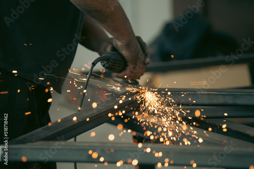 Close up on a man held an angle grinder to cut an iron with sparks © erika8213