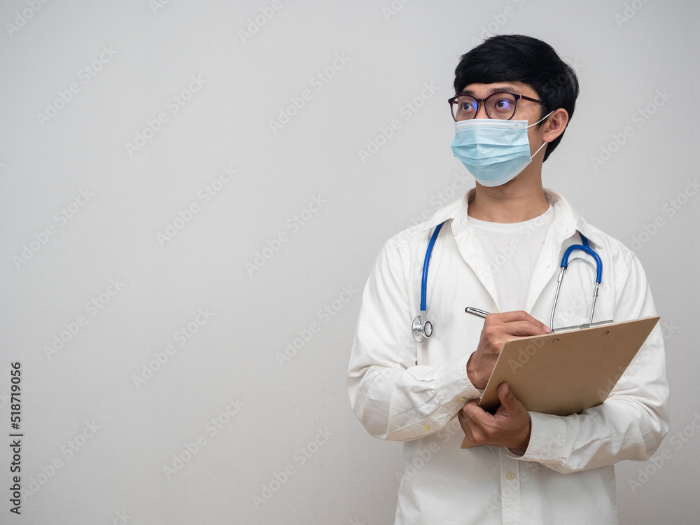 Doctor wearing mask hold check list looking at copy space Doctor wearing mask hold check list looking at copy space