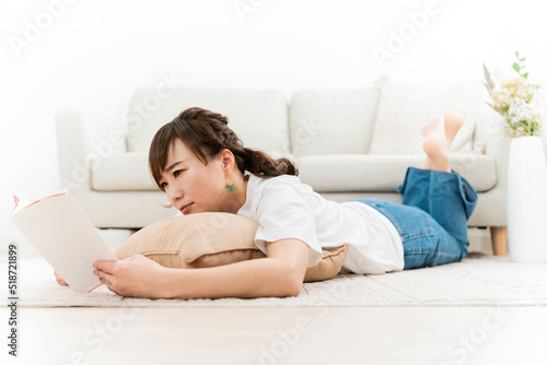 家のリビングで読書をする日本人女性（困る） 