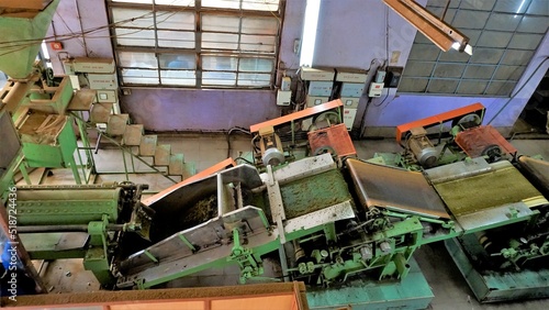 Assembly line of processing of tea leaves by machines from raw material leaves to finished tea power. Leaves are turned into packed tea through various stages. photo