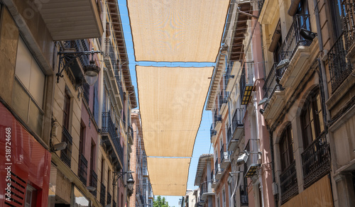 Toldos de tela entre edificios para proteger del sol durante los días calurosos de verano en la ciudad de Granada, España