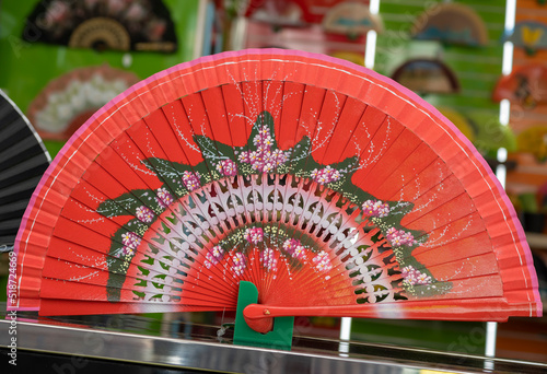 Un hermoso y tradicional abanico español de color rojo para darse aire durante los calurosos días de verano photo