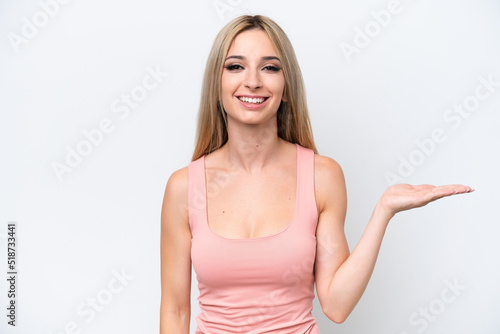 Pretty blonde woman isolated on white background holding copyspace imaginary on the palm to insert an ad