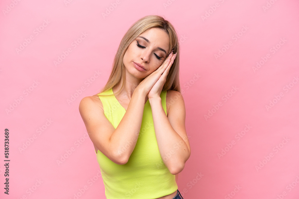 Fototapeta premium Pretty blonde woman isolated on pink background making sleep gesture in dorable expression